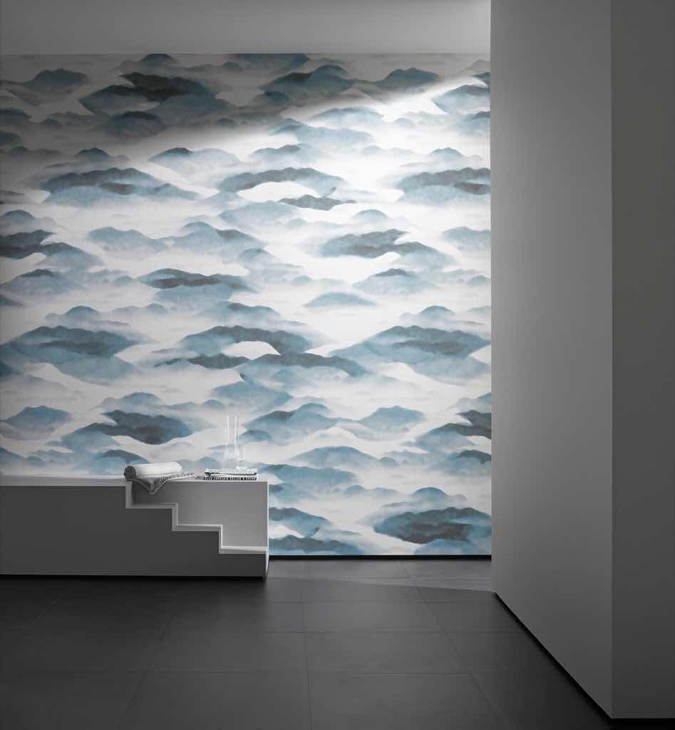 Das japanisch anmutende Dessin der tief hängenden Wolken inmitten einer weitläufigen Berg-Silhouette wird im Digitaldruck auf die Kettfadenkaschierung des Artikels PURO gedruckt. Der feine Moiré des Viskosegarnes kommt auf den unbedruckten Stellen besonders gut zur Geltung. FUJI ist als 210 x 350 cm großes Wandbild erhältlich